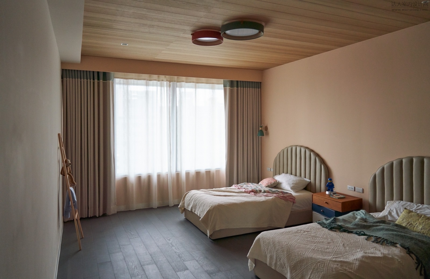 主卧室可见整墙的柜体使用夹板染色带出材质自然的大片木纹,湛蓝色调